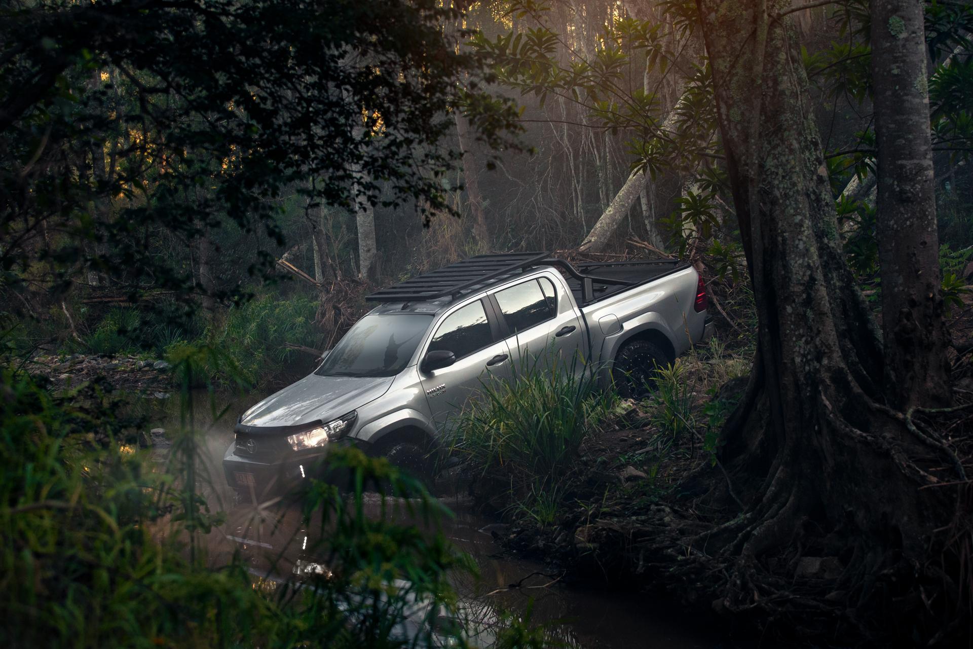 a ute driving offroad through woods